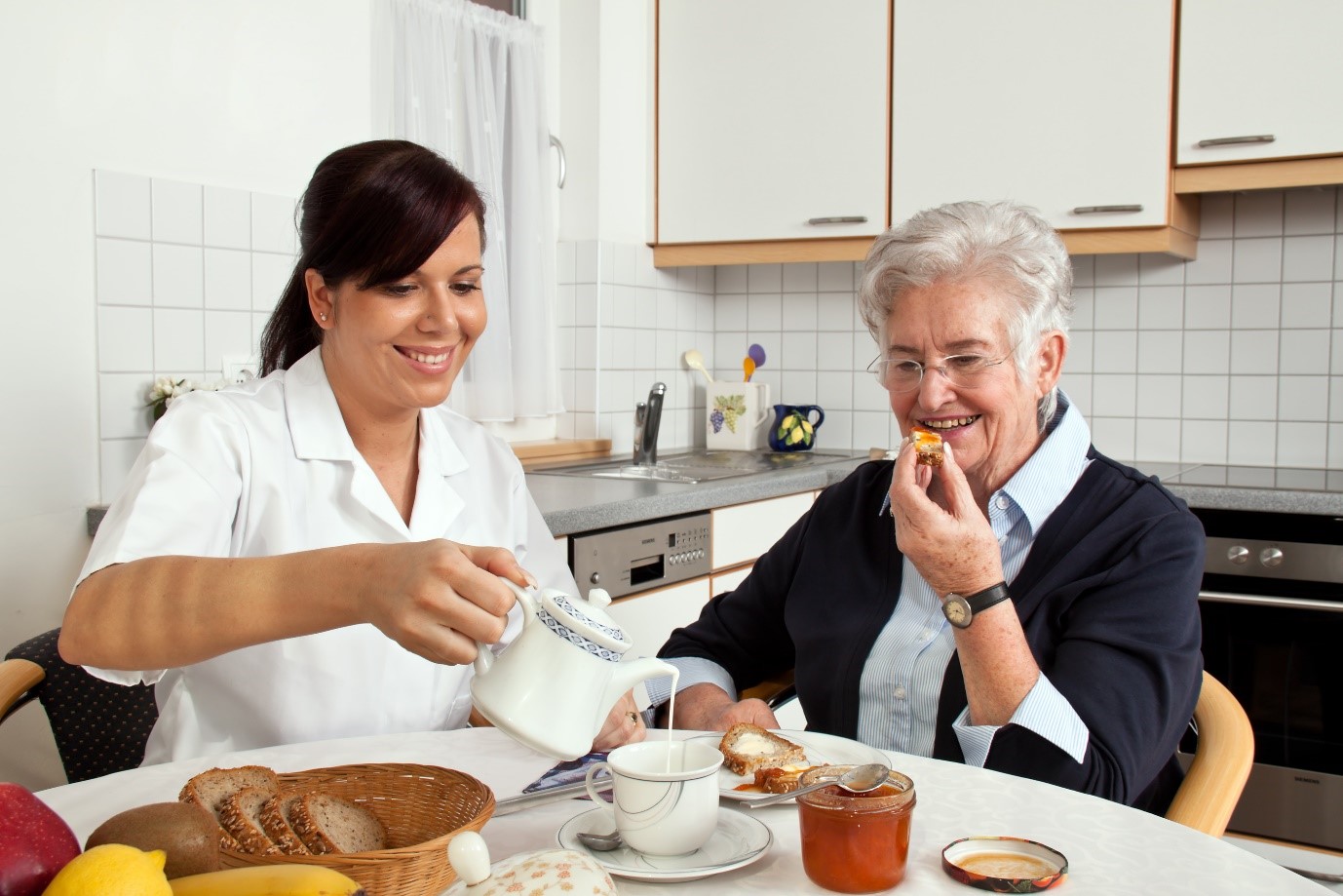 Dietitian and coeliac disease client sitting at kitchen table eating breakfast