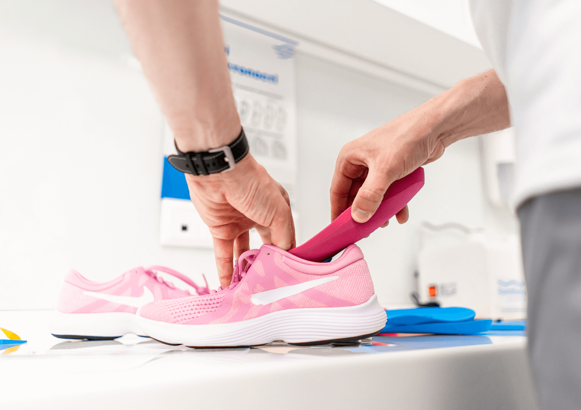 A man putting custom orthotics into a shoe